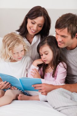 Portrait of a family reading a book clipart