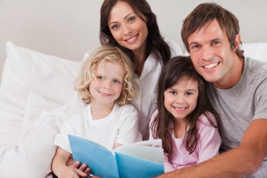 Happy family reading a book clipart