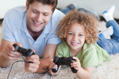 Happy boy and his father playing video games clipart