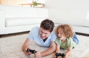 Cheerful boy and his father playing video games clipart