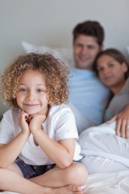 Portrait of a boy sitting on his parents's bed clipart