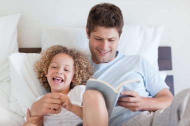 Father reading bedtime story for child clipart