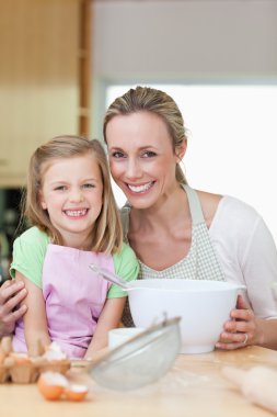 Mother and daughter having good time in the kitchen clipart