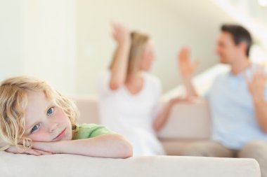 Sad boy with fighting parents in the background clipart