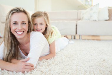 Mother and daughter lying on the floor clipart