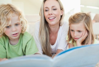 Mother reading magazine with her children clipart