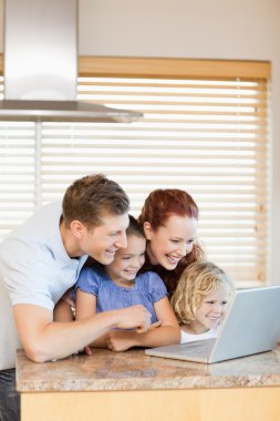 Family exploring the internet in the kitchen clipart