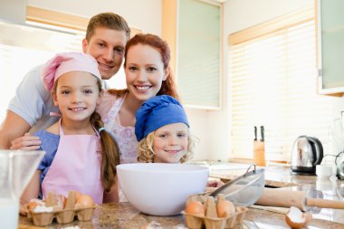 Cheerful family preparing dough clipart