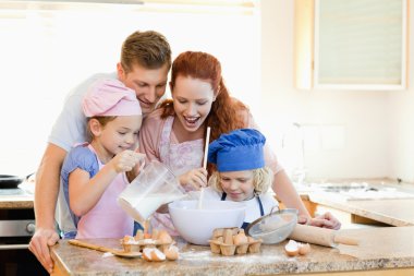 Family having a great time baking together clipart