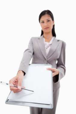 Clipboard and pen being handed over by businesswoman clipart