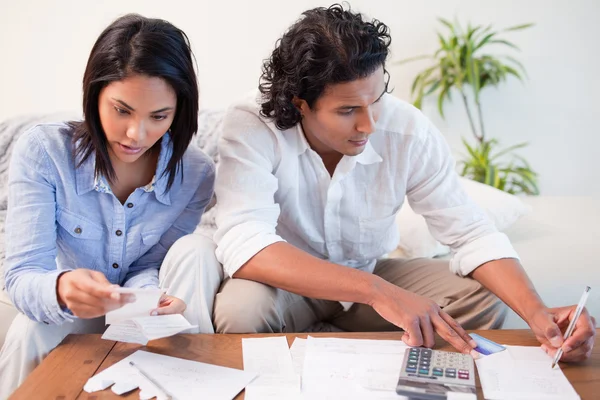 Ehepaar checkt Rechnungen im Wohnzimmer — Stockfoto