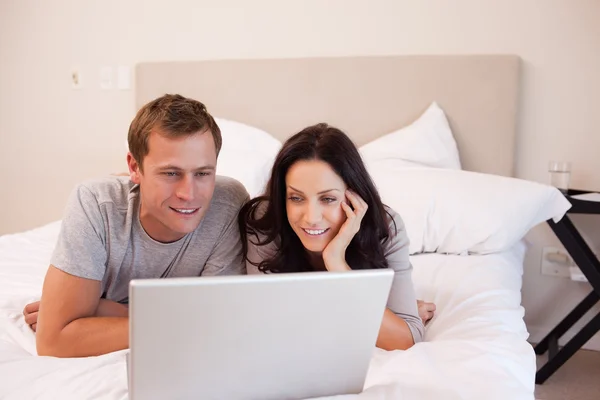 Пара використовує ноутбук на ліжку разом — стокове фото