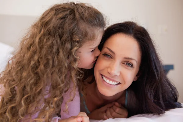 Little daughter giving her mother a kiss — Stock Photo, Image