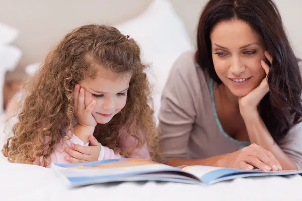 Kleines Mädchen liest Gute-Nacht-Geschichte mit ihrer Mutter — Stockfoto