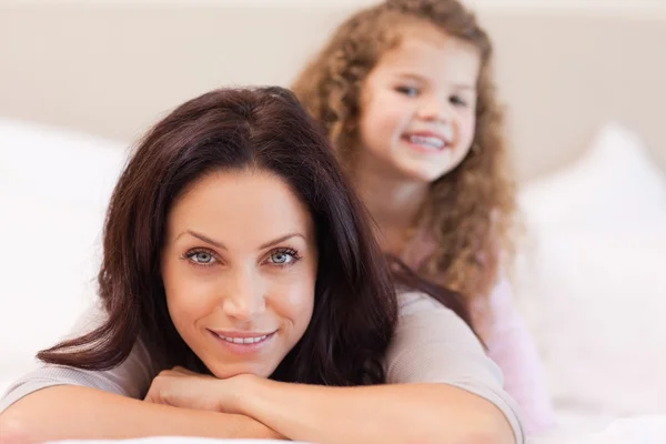 Mother and daughter relaxing on the bed — Stock Photo, Image