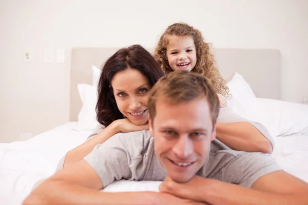 Играющая семья проводит время в спальне — стоковое фото