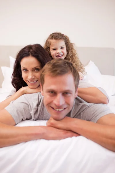 Familjen avkopplande på sängen tillsammans — Stockfoto