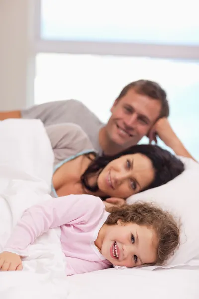 Семья лежит на кровати вместе — стоковое фото