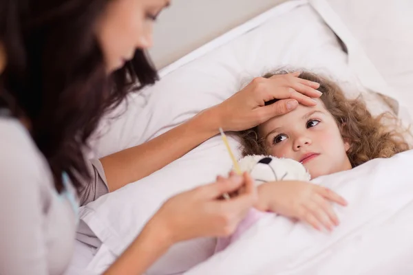 Mother taking care of her sick daughter — Stock Photo, Image