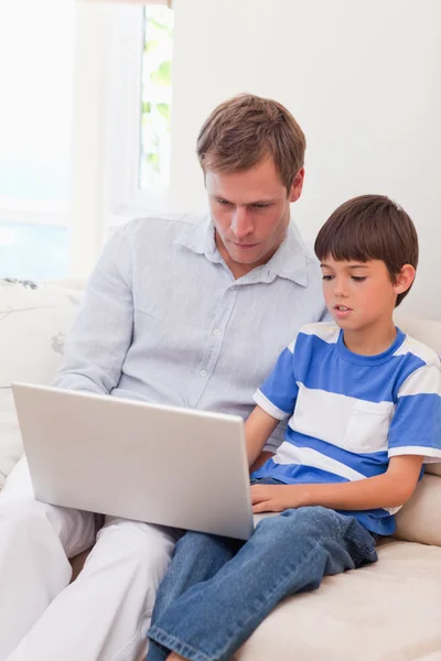 Pai e filho navegando na internet juntos — Fotografia de Stock