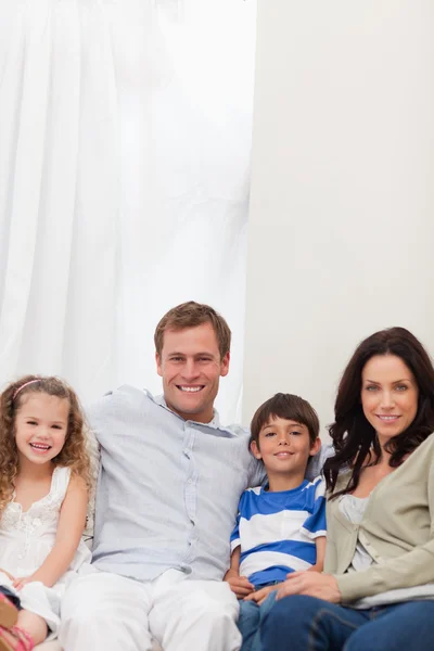 Famiglia sorridente seduta sul divano insieme — Foto Stock