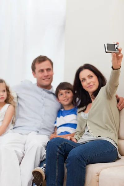 Mãe tirando foto de família no sofá — Fotografia de Stock
