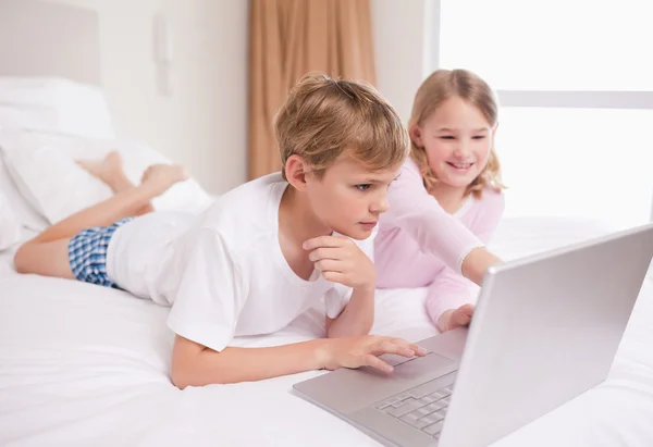 Siblings using a notebook — Stock Photo, Image