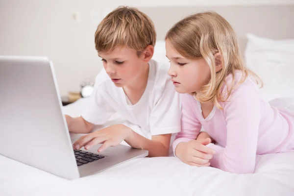 Şirin çocuk bir dizüstü bilgisayar kullanarak — Stok fotoğraf