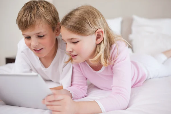 Siblings using a tablet computer — Stock Photo, Image