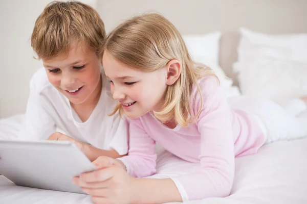 Uśmiechający się rodzeństwem przy użyciu komputera typu tablet — Zdjęcie stockowe