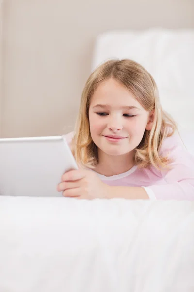 Retrato de uma menina sorridente usando um computador tablet — Fotografia de Stock