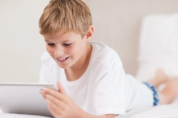 Uśmiechnięty chłopiec przy użyciu komputera typu tablet — Zdjęcie stockowe