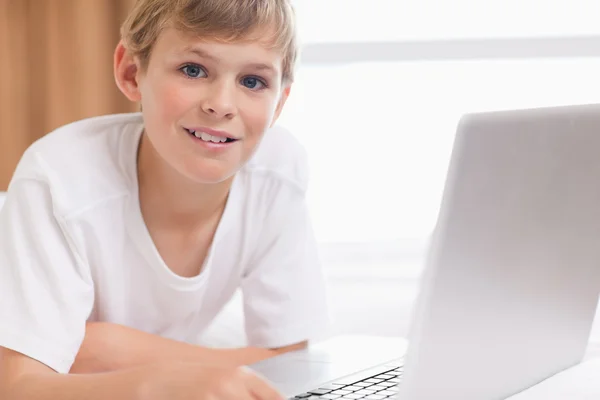 Sorrindo menino usando um laptop — Fotografia de Stock