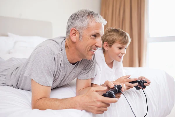 Sonriente padre y su hijo jugando videojuegos — Foto de Stock