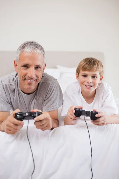 Portret van een jongen en zijn vader spelen van videospellen — Stockfoto