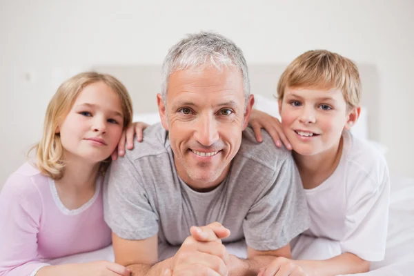 Cute siblings and their father posing — Stock Photo, Image