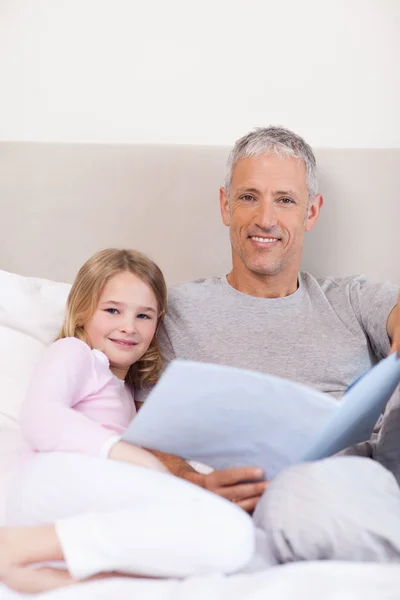 Portrait of a father reading a story to his daughter — Stock Photo, Image