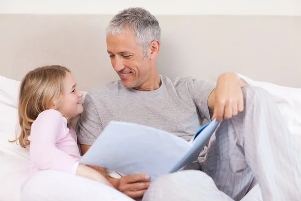 Père heureux lisant une histoire à sa fille — Photo
