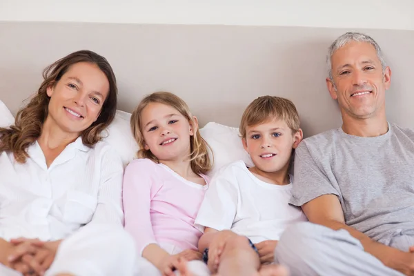 Family lying on a bed — Stock Photo, Image