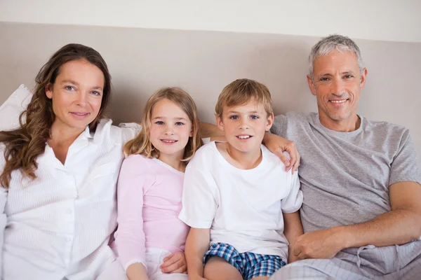 Happy family lying on a bed — Stock Photo, Image