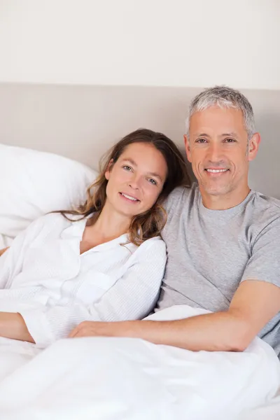 Retrato de um casal deitado em uma cama — Fotografia de Stock