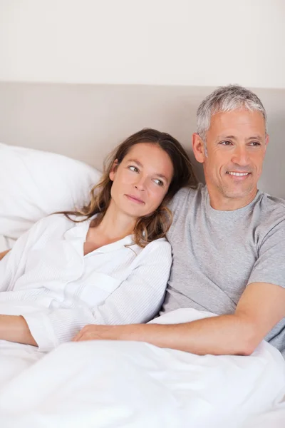 Portret van een gelukkige paar liggend op een bed — Stockfoto