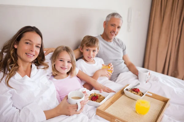 Familia feliz desayunando en un dormitorio — Foto de Stock