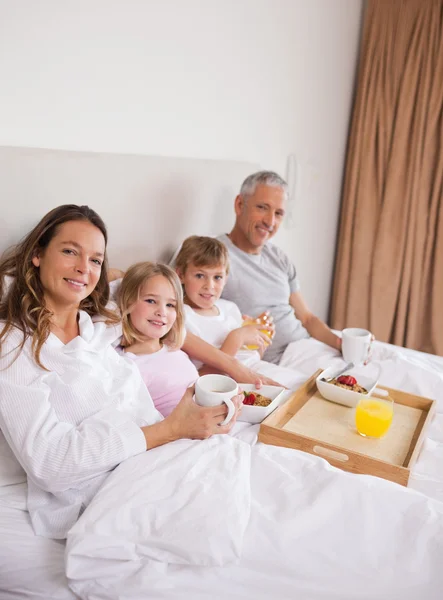 Portretul unei familii care ia micul dejun în dormitor — Fotografie, imagine de stoc