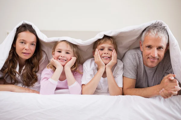 Familjen ligger under ett täcke — Stockfoto