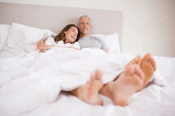 Charming couple lying in a bed — Stock Photo, Image