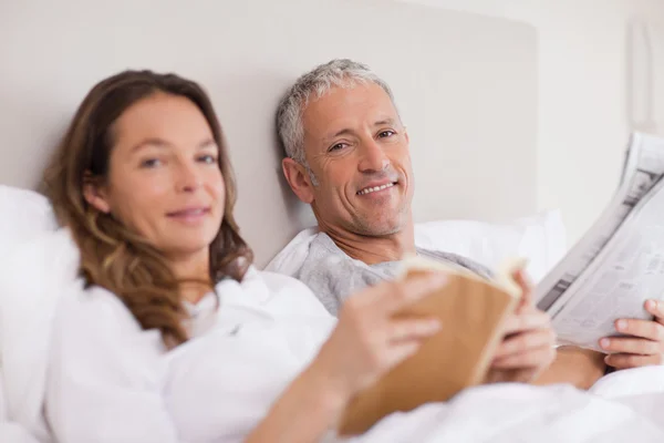 동안 그녀의 남편이 뉴스를 읽고 책을 읽고 행복 한 여자 — 스톡 사진