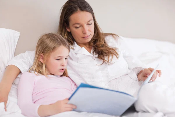 可爱的女孩和她的母亲读一本书 — 图库照片