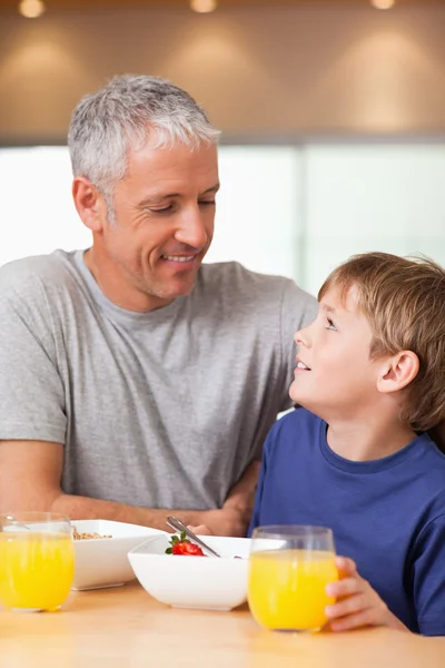 Portrait of a young boy and his father having breakfast — Stock Photo, Image