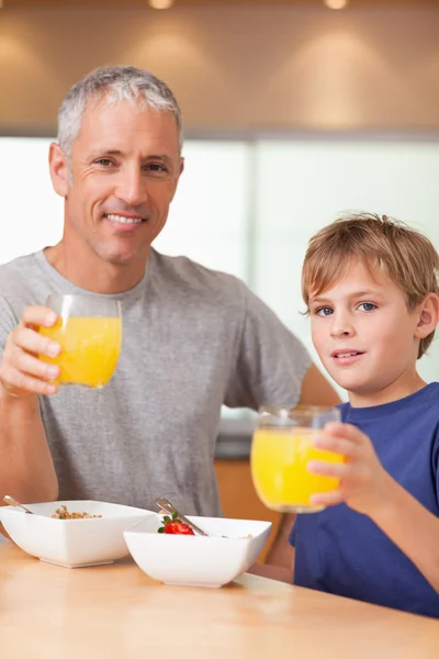 Portrait of a cute boy and his father having breakfast — Stock Photo, Image